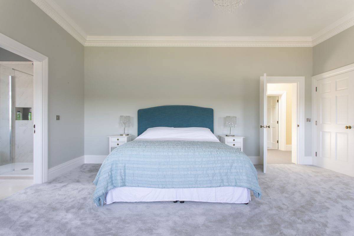 Serene duck-egg blue double bedroom with a large bed and premium carpets for lifestyle brand photography, Love Locations venue.