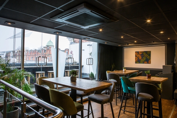 Bright upper-floor seating zone with floor-to-ceiling glass windows overlooking Brixton Town Centre, perfect for modern drama series scene filming, Love Locations.