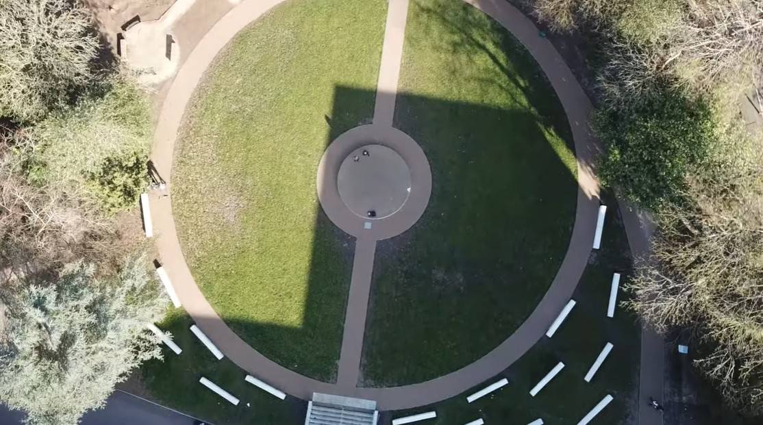 Love Locations campus drone photography Reading: Perfect top-down vertical aerial perspective mapping out a circular lawn, concrete footpaths, and modern architectural shadow lines.