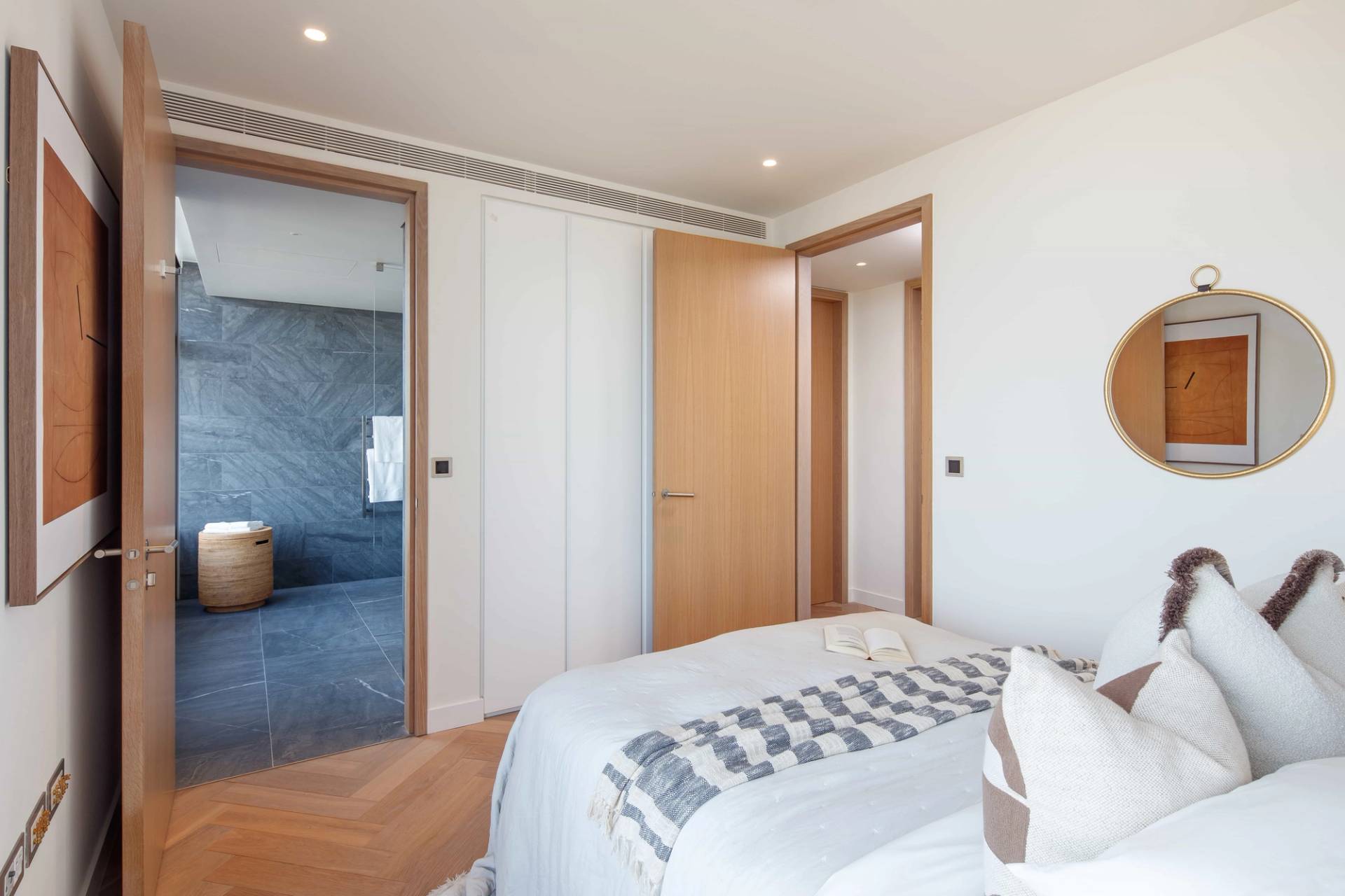 Penthouse bedroom doorway transition leading into a dark marble ensuite bathroom, Love Locations EC2A.