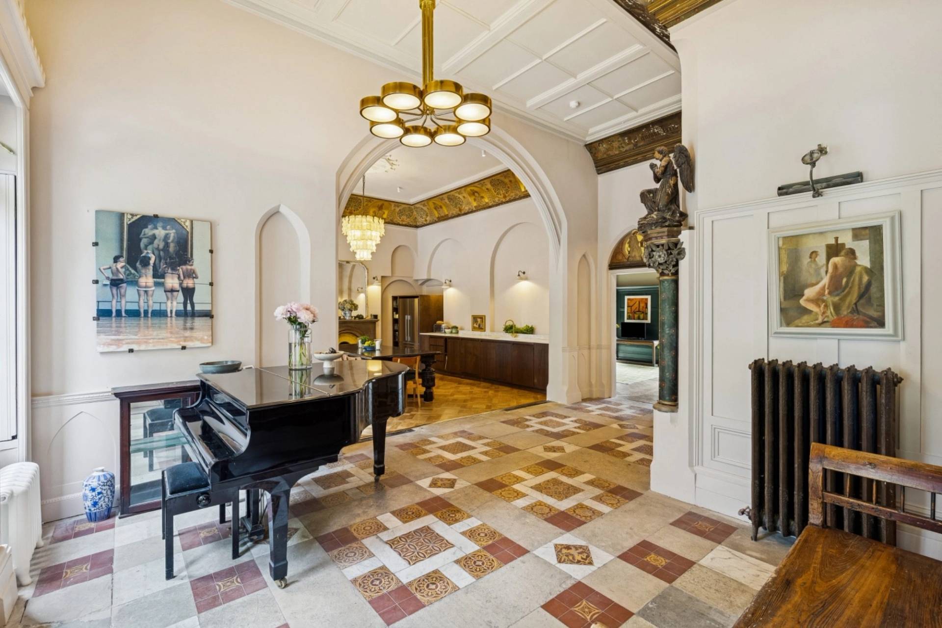 Grand entrance hall production space in a gothic revival home in Hampstead London via Love Locations, with patterned tile floors and vaulted archways.