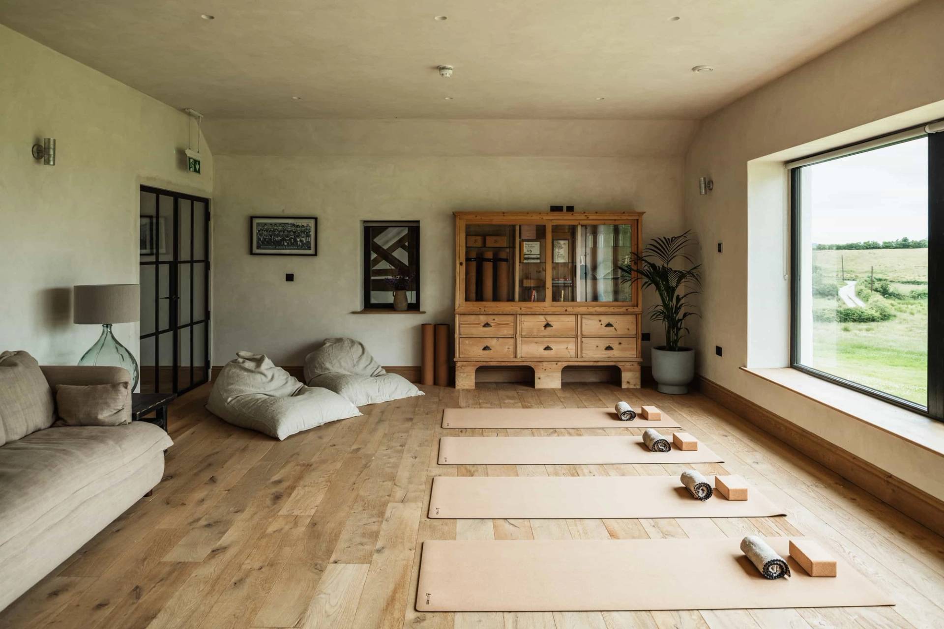Yoga and wellness studio location in Castleblayney County Monaghan Ireland via Love Locations, with timber flooring, yoga mats, beanbags, and bright countryside windows.