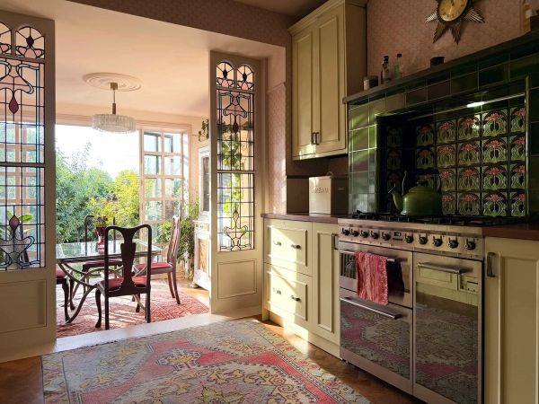 Charming Edwardian kitchen location with cream cabinetry, Range cooker, green glazed tiles, and pink walls, Love Locations N13.
