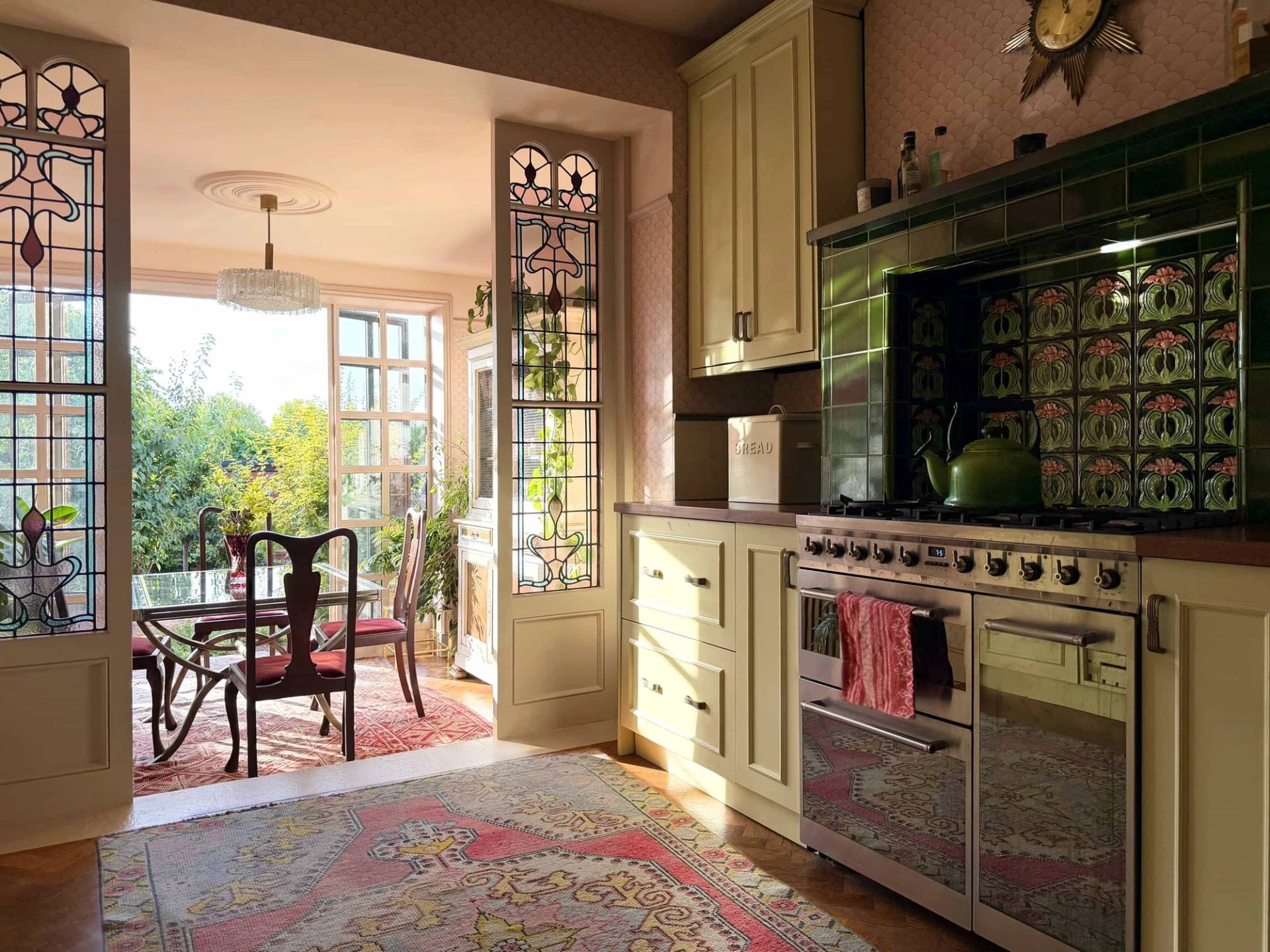 Charming Edwardian kitchen location with cream cabinetry, Range cooker, green glazed tiles, and pink walls, Love Locations N13.