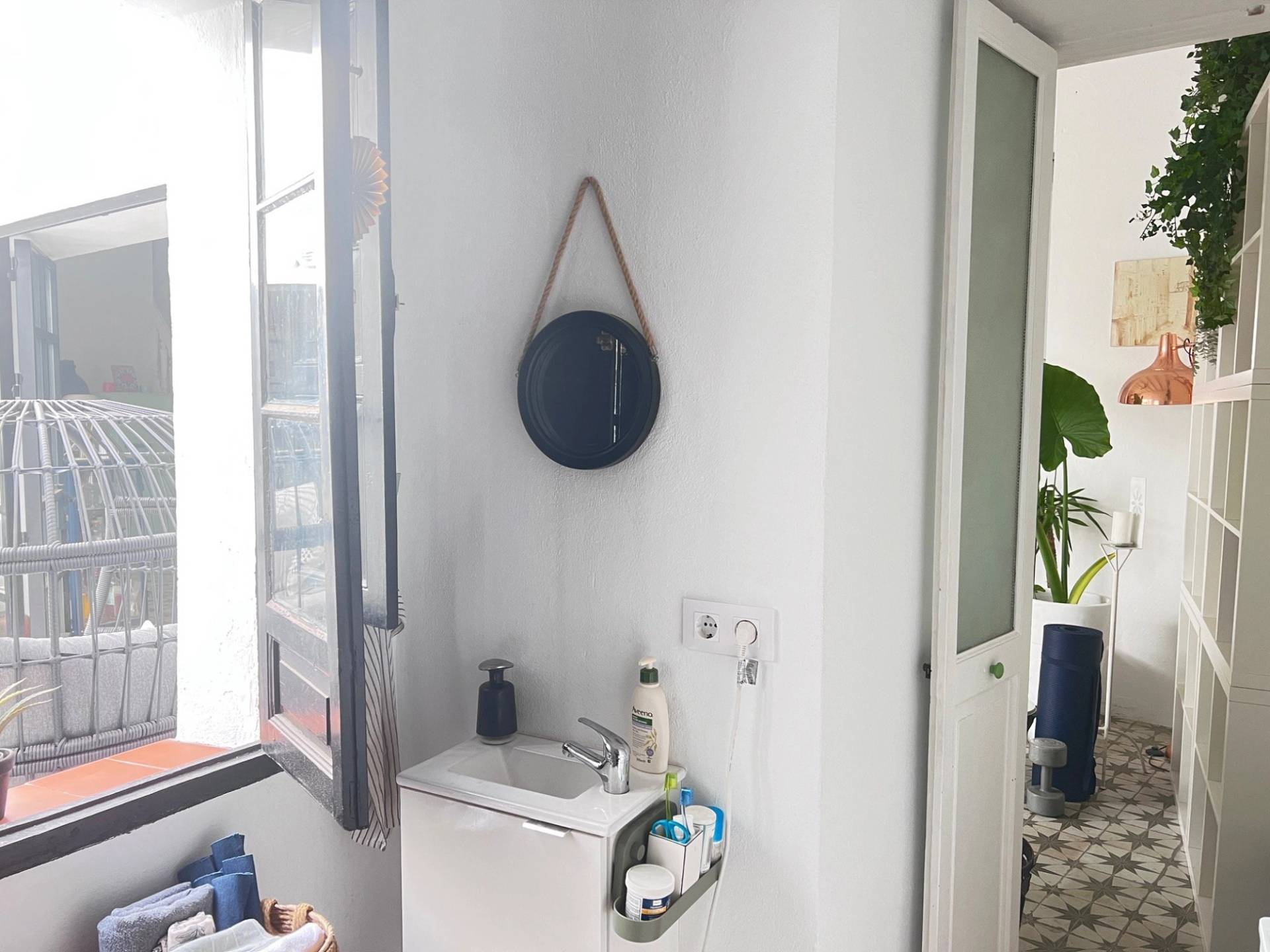 Compact powder room bathroom location with hanging round wall mirror in Jimena de la Frontera through Love Locations.