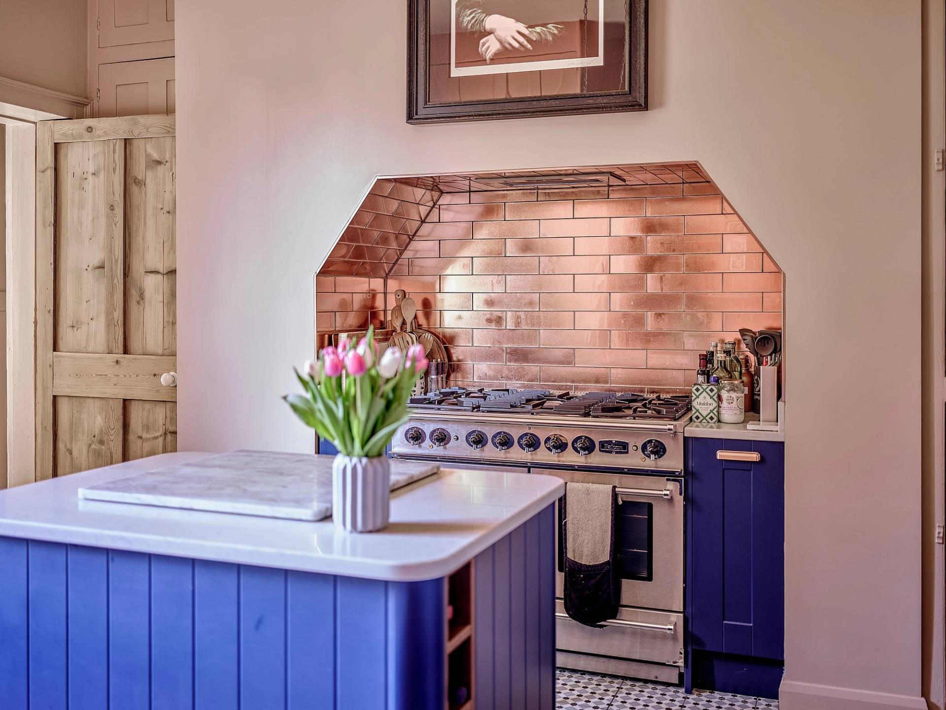 Close-up of a range cooker set inside a copper-lined kitchen alcove with cobalt blue island units, perfect for appliance marketing, Love Locations ME13.