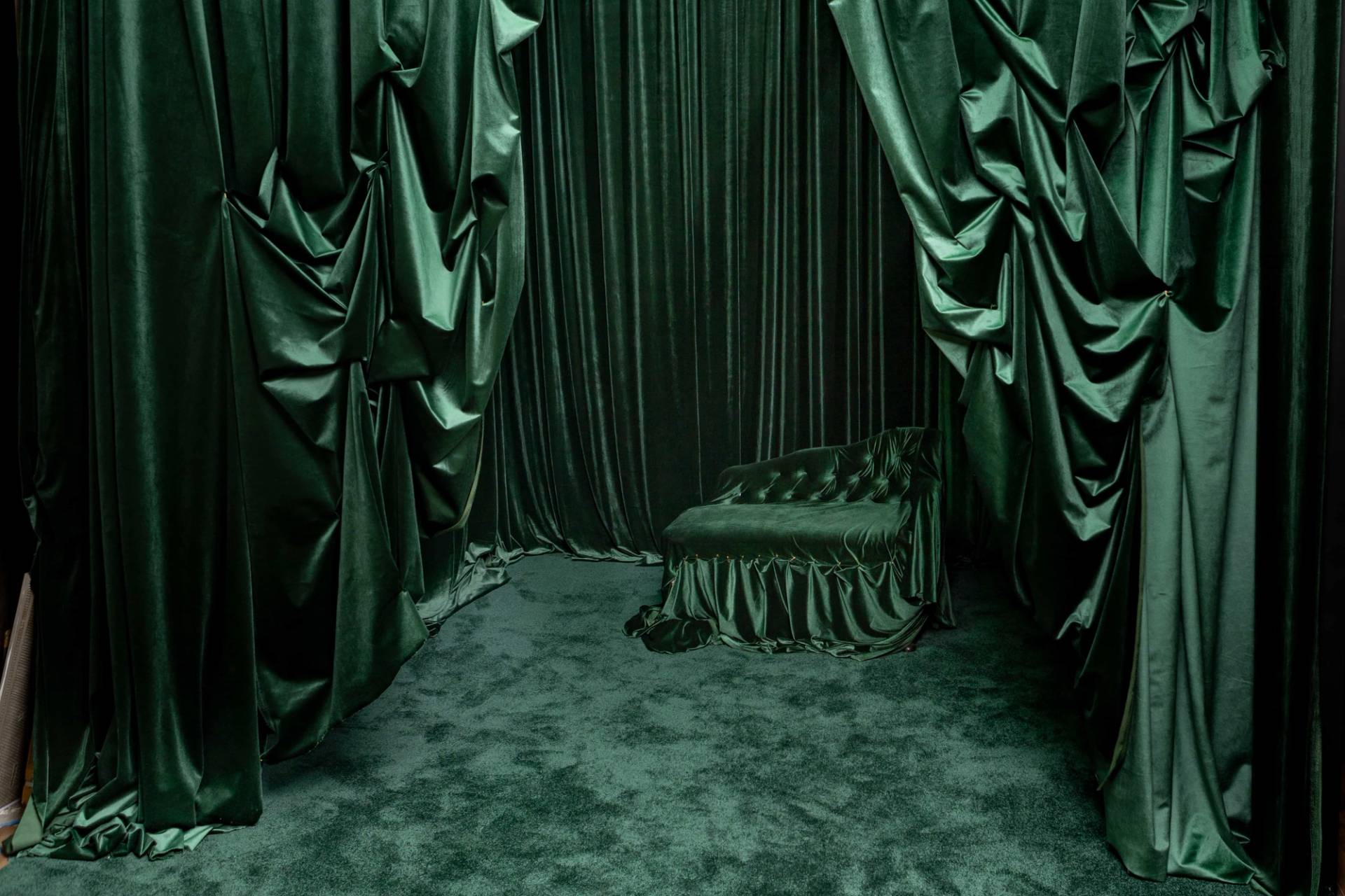 Emerald green studio set featuring floor-to-ceiling emerald velvet drapes, green carpet, and a velvet chaise lounge, Love Locations N15.