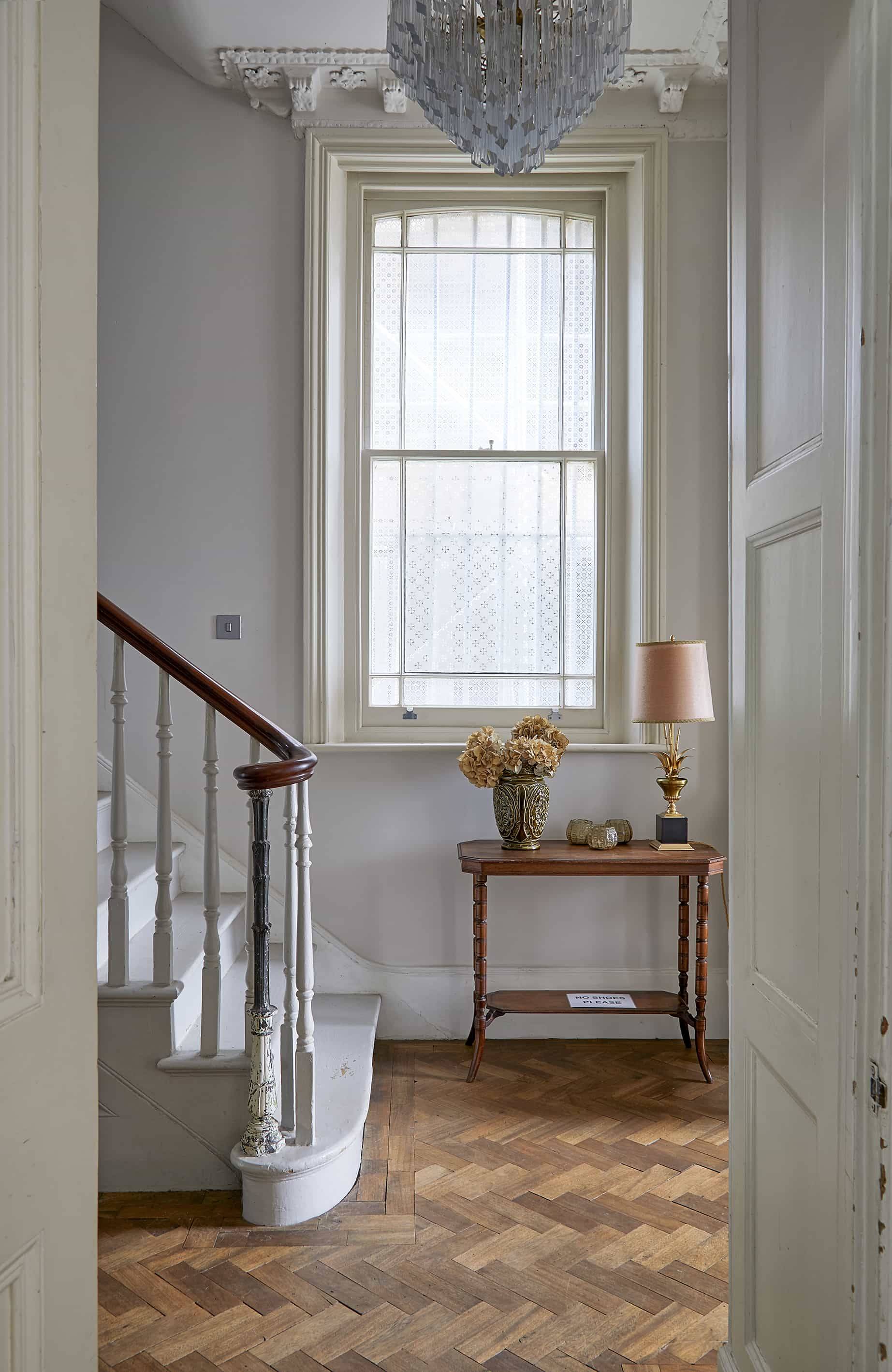 Grand entrance hallway featuring a mahogany stair balustrade, sash window, and console table, Love Locations N16.