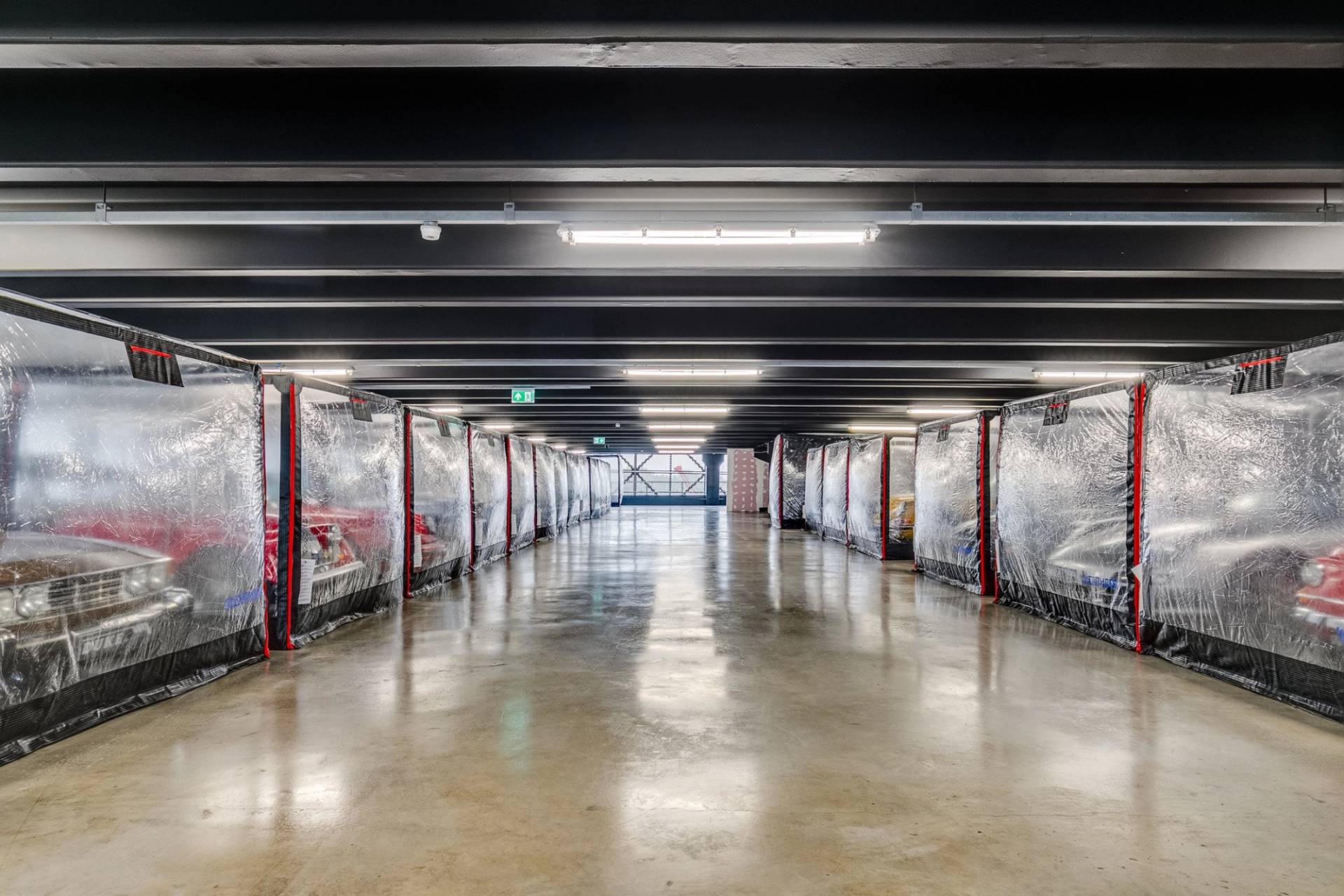 Clean industrial car storage facility film location in Brentford TW8 through Love Locations, featuring rows of vehicles in clear protective bubbles.