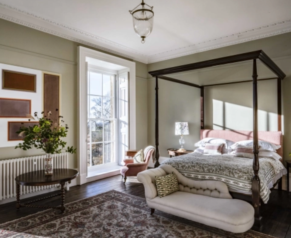 Elegant four-poster bedroom at Keythorpe Hall featuring original sash windows, heritage interiors and luxury country house styling.