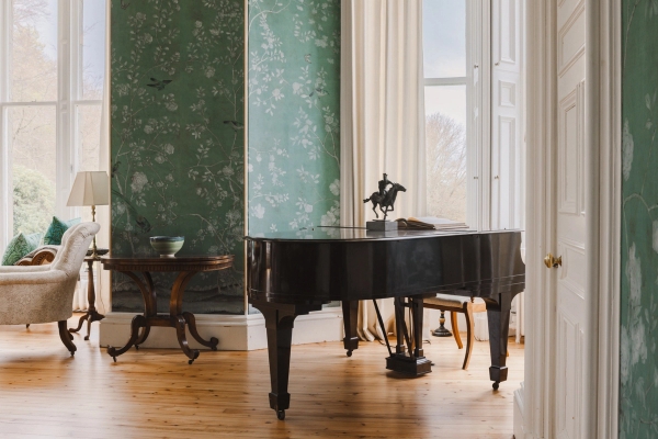 Grand piano positioned in a green drawing room beside large sash windows in a Scottish castle, Love Locations KY15.