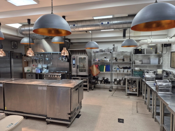 Fully equipped culinary location space featuring industrial ovens and overhead dome lighting for food media productions, listed on Love Locations.
