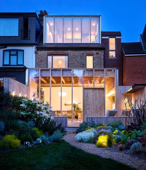 Illuminated rear extension and top-floor glass loft dormer at twilight on a 1930s house, Love Locations E17.