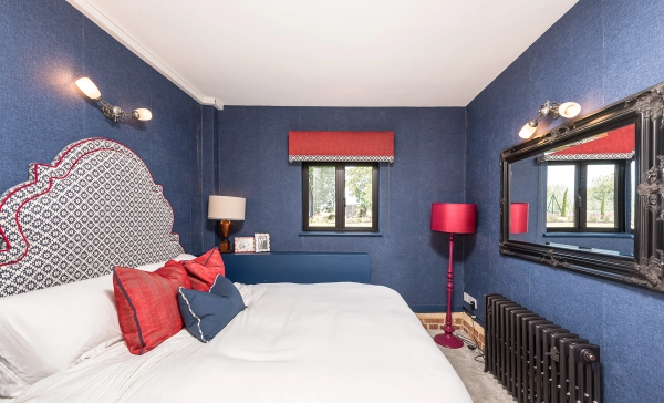 Deep blue painted bedroom setting with a plush double bed for dramatic TV or editorial filming production, Love Locations CM3.