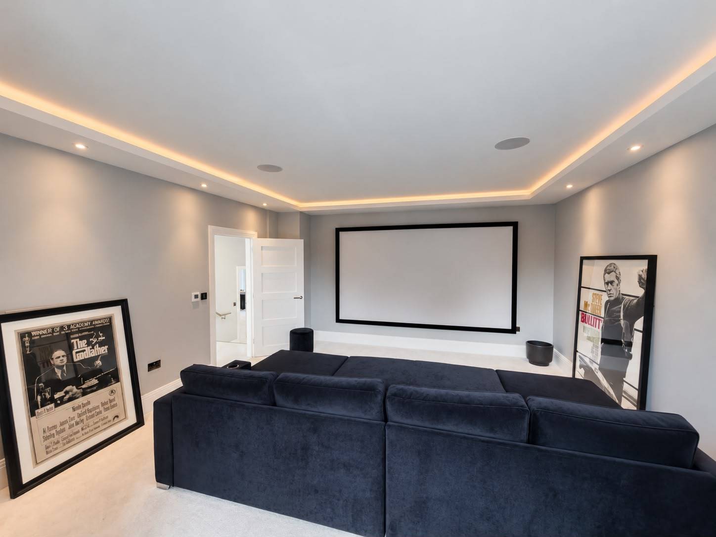 Private media room and screening room film location in Barnet EN4 through Love Locations, showcasing a large projection screen, dark seating, and recessed ceiling lights.