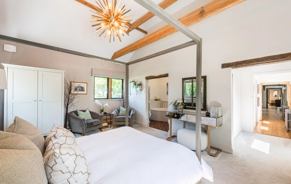 Bright and airy residential bedroom shoot space with neutral styling and exposed timber support pillars, listed on Love Locations.