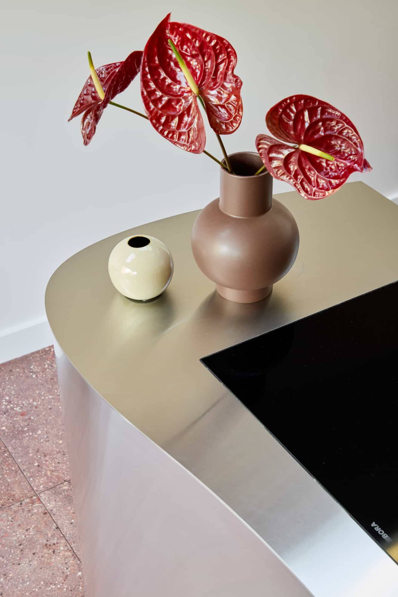 Love Locations premium interior design backdrop Lewisham: Close-up of a brushed steel countertop styled with ceramic vases, optimized for luxury brand campaigns and product placement.