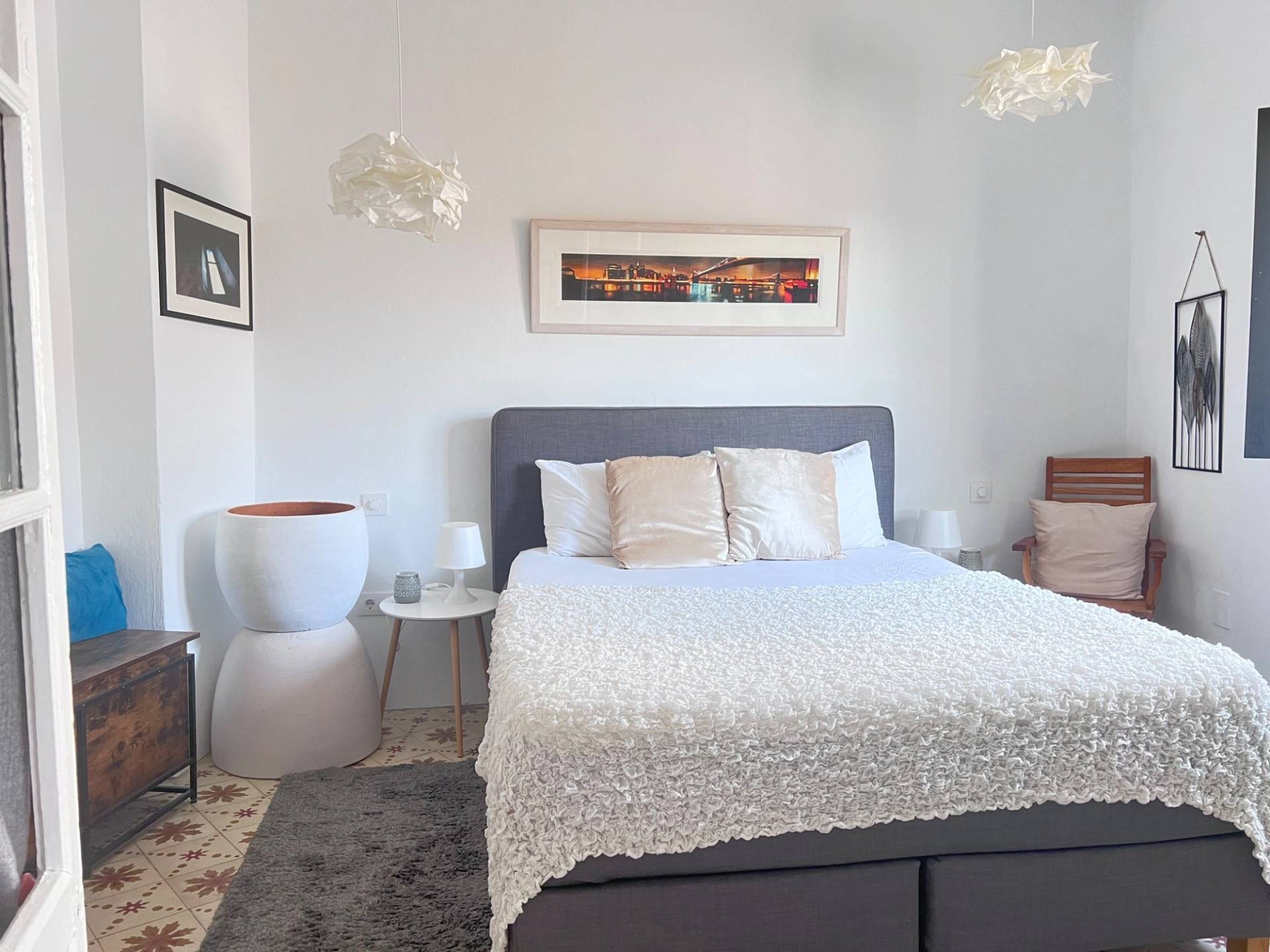 Airy double bedroom shoot location in Jimena de la Frontera by Love Locations, featuring clean white bedding, wall art, and bright daylight.