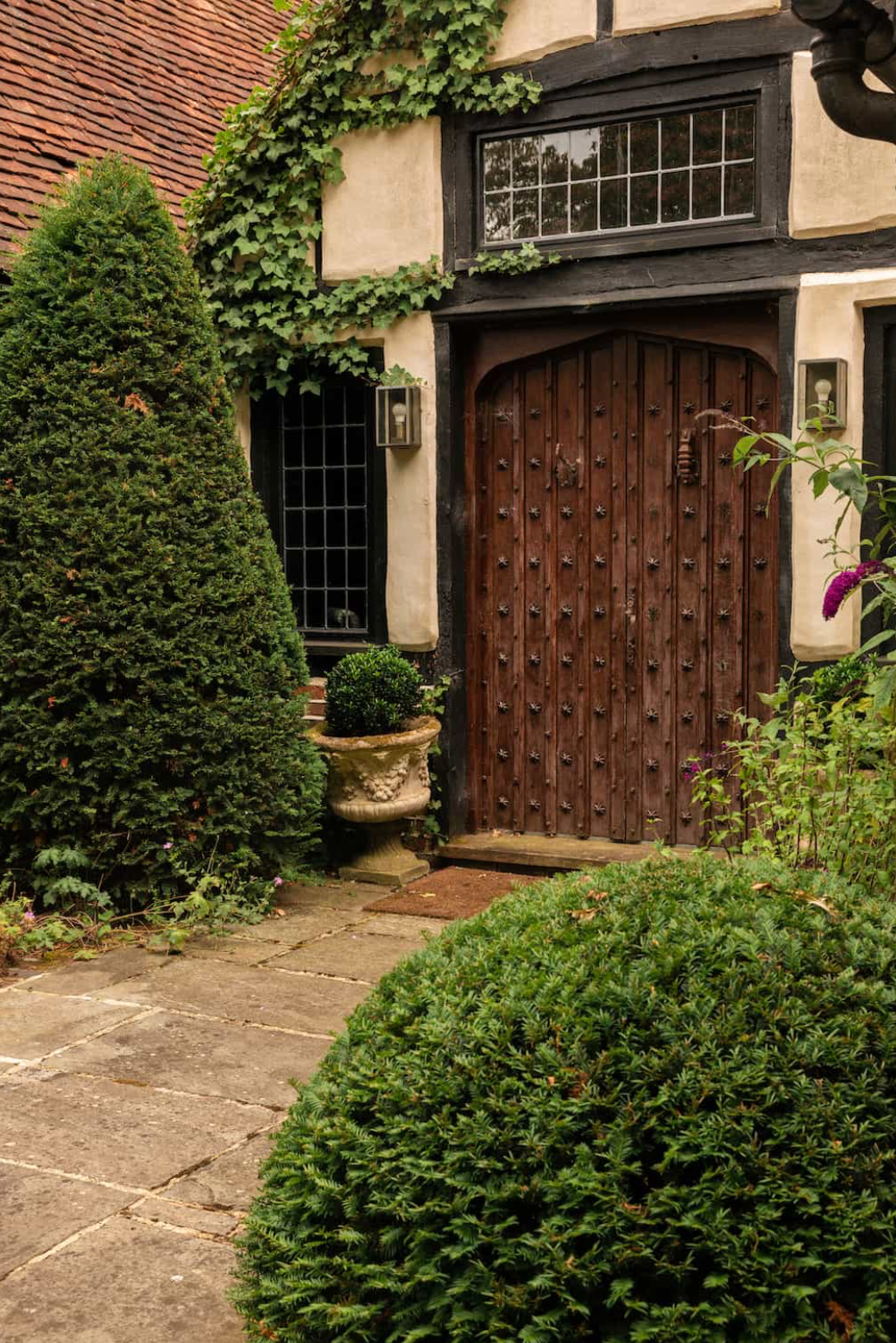 Original Tudor front door at Agatha, a 16th-century country house location featuring timber framing, ivy-covered walls and historic architectural details.