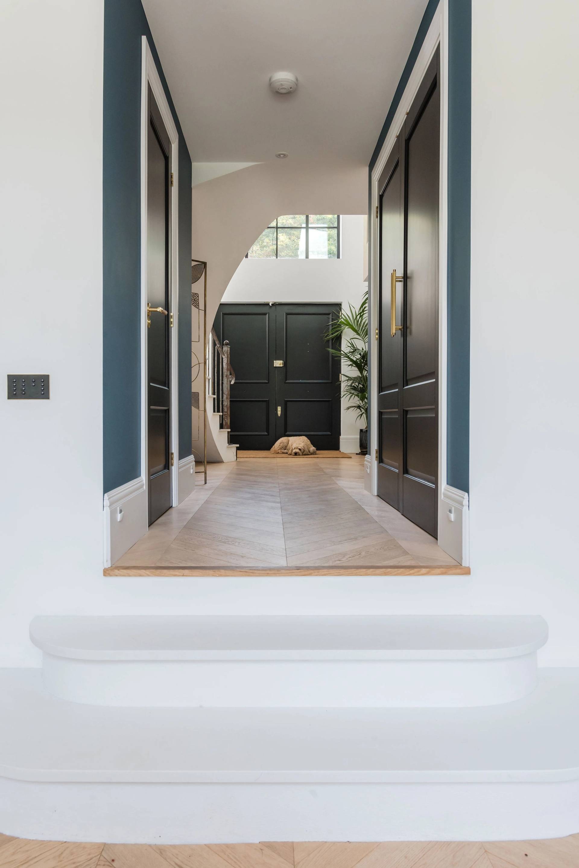 Grand entrance hall perspective showing white marble steps leading into a dark teal inner hallway, Love Locations GU3.