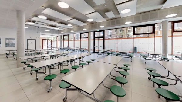 Modern school cafeteria shoot location with industrial ceilings and rows of lunch tables, available for hire on Love Locations.