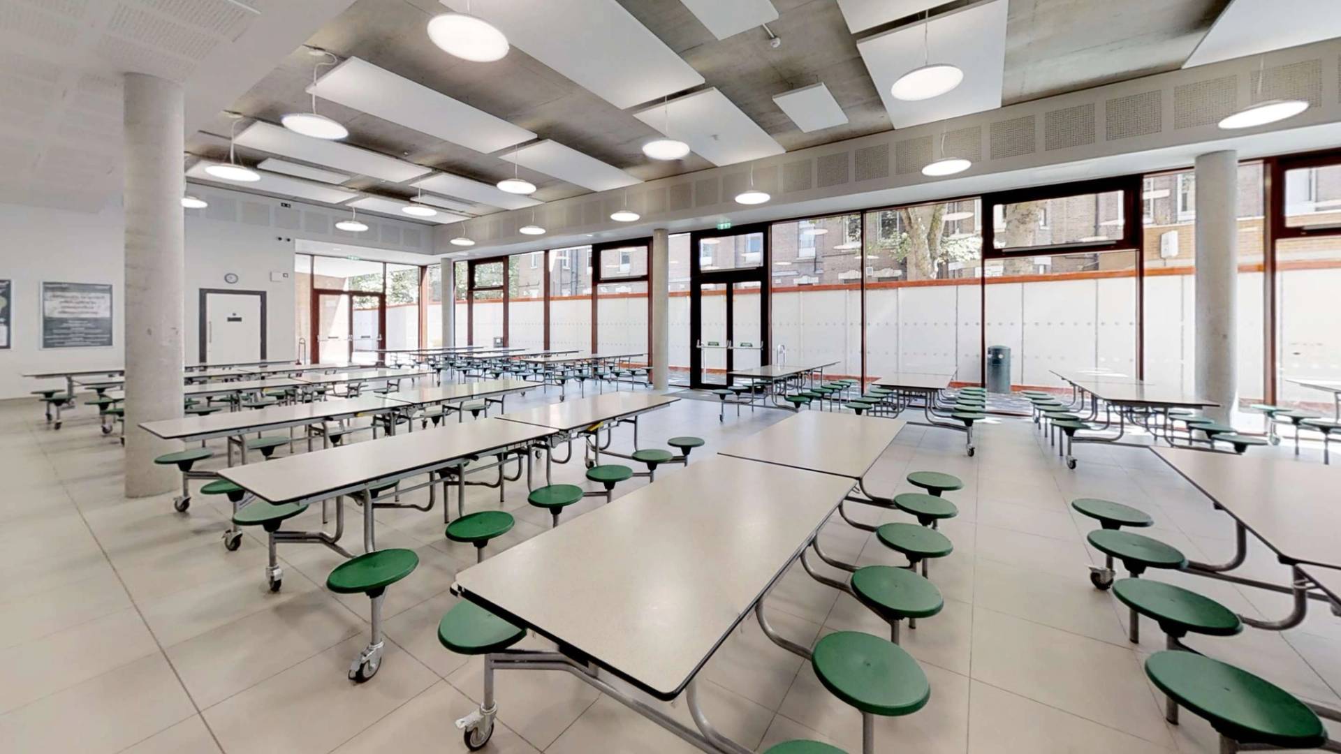 Modern school cafeteria shoot location with industrial ceilings and rows of lunch tables, available for hire on Love Locations.