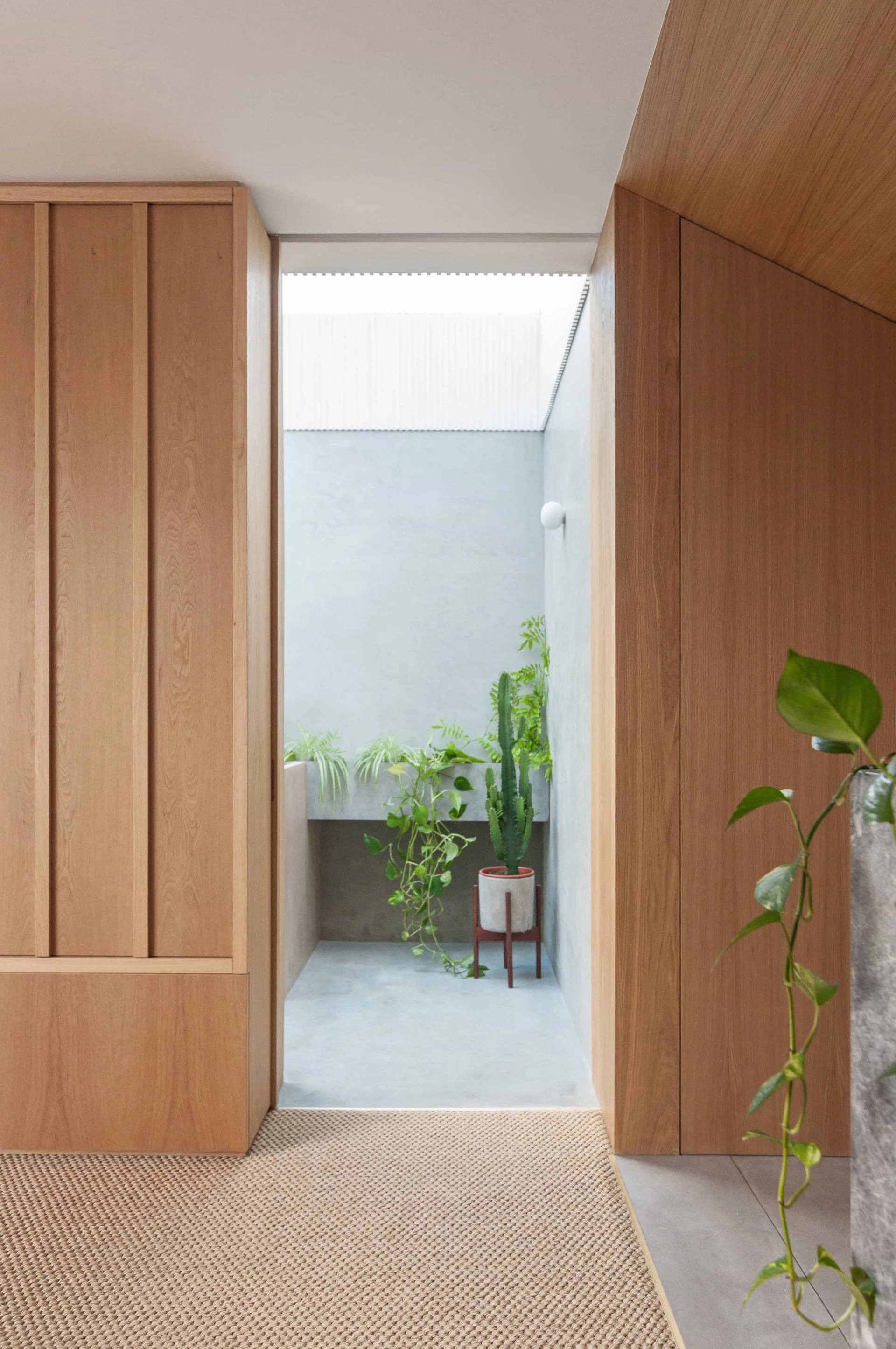 Sunlit hallway transition between bedroom and bathroom with light wood paneling in Hackney London N16 from Love Locations.