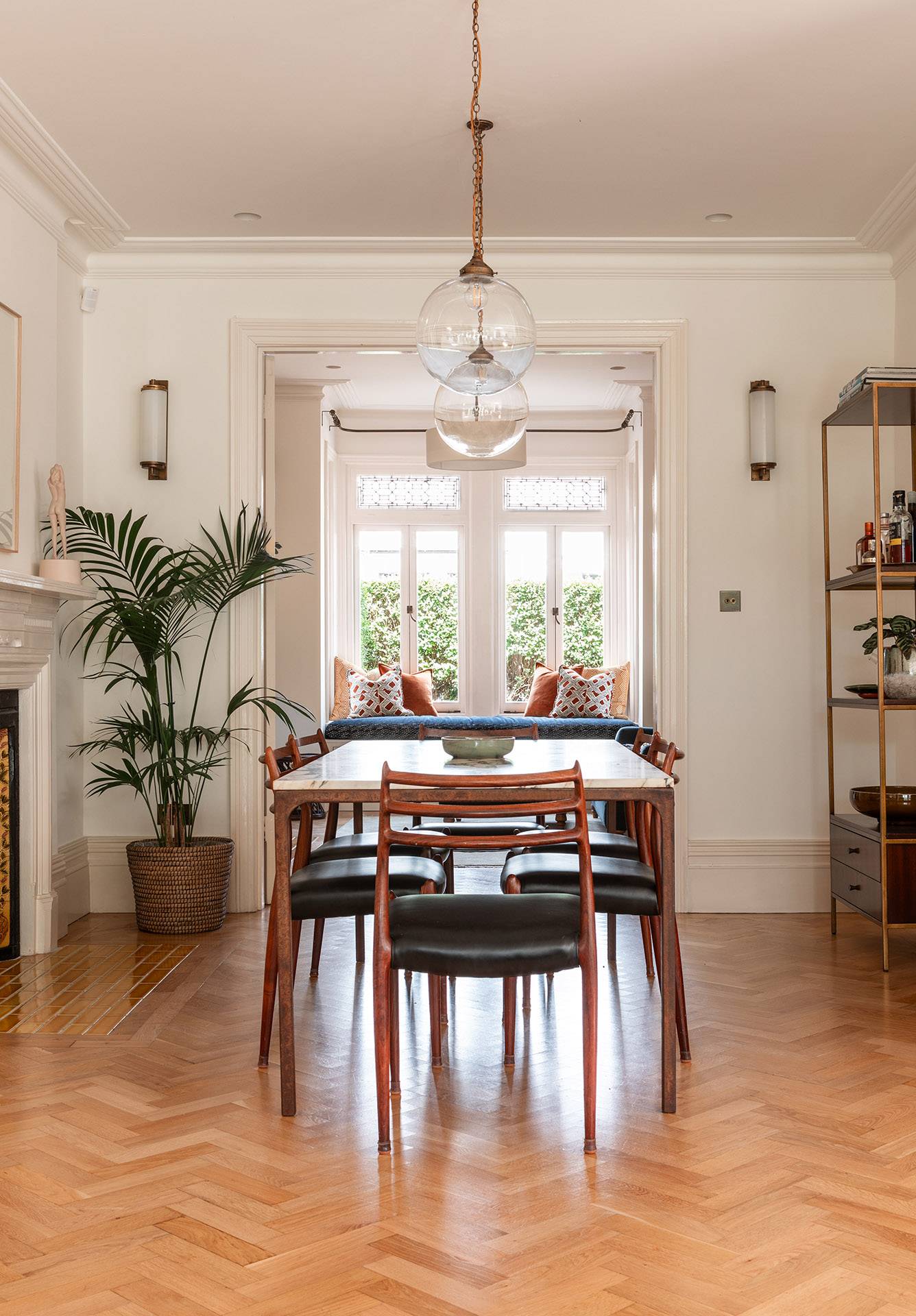 Light-filled dining room layout looking through an archway into a window seat lounge area, perfect for home decor lookbooks, Love Locations.