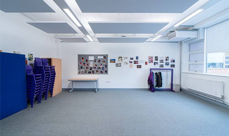 Clean studio room location house in Hove BN3 with purple display boards, clothes rail, and gray carpeting via Love Locations.