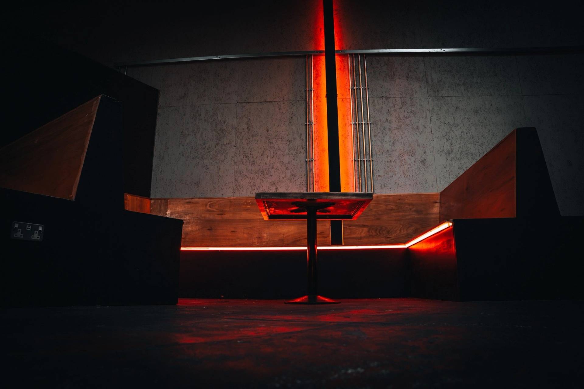 Modern wooden bench booth seating lined with red LED perimeter lighting in a Cheetham Hill venue from Love Locations.