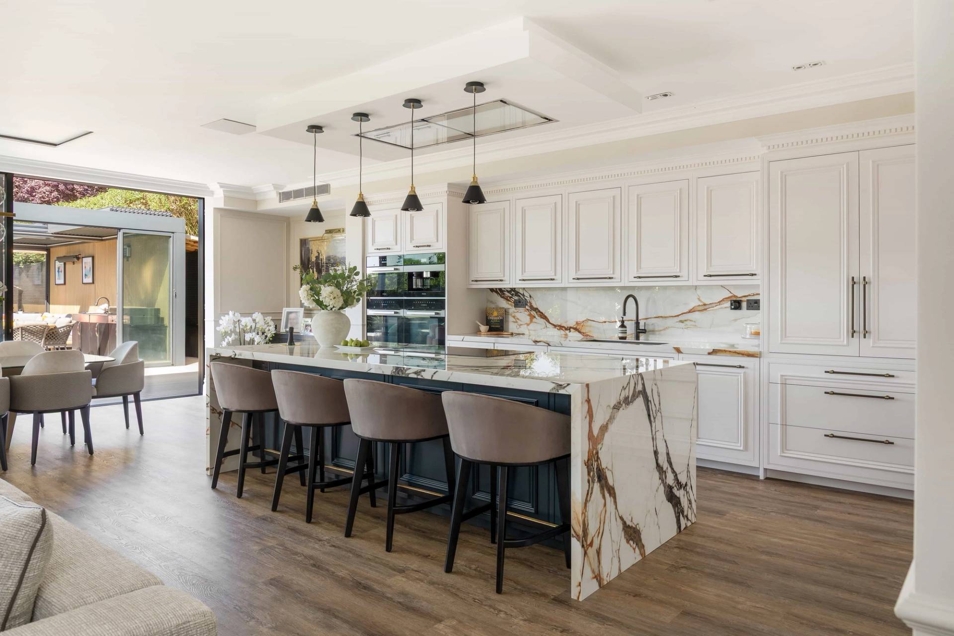 Luxury modern kitchen shoot location in Ealing, W5 featuring a marble island with gold veins, shaker cabinets, and velvet bar stools via Love Locations.