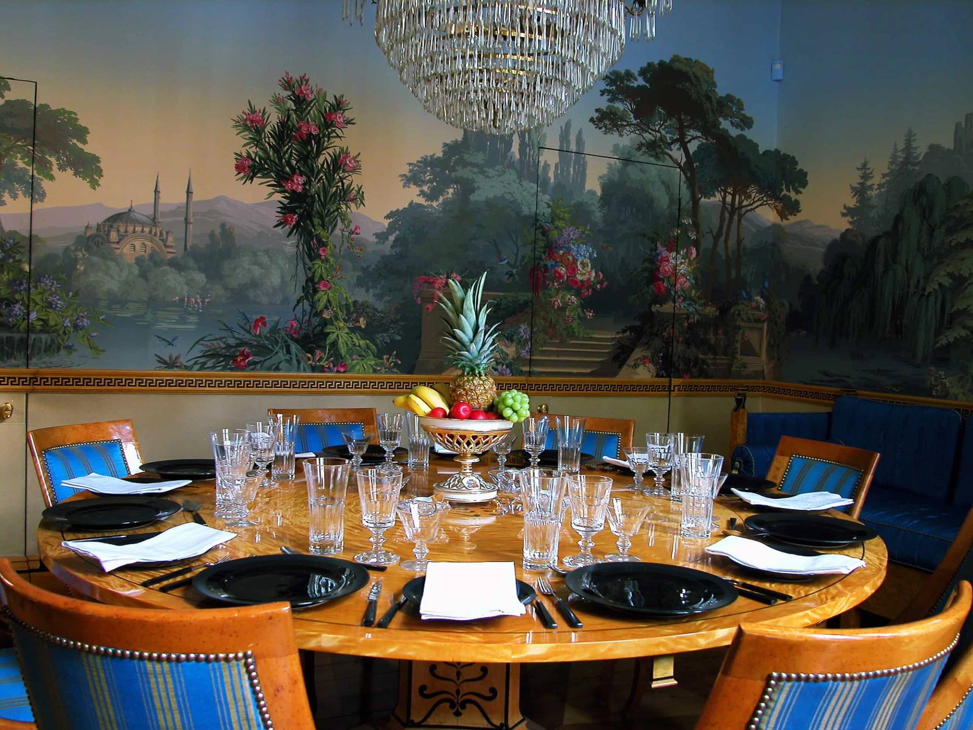 Scenic mural dining room detail showcasing fine crystal glassware, polished timber table, and warm lighting in West London, Love Locations.