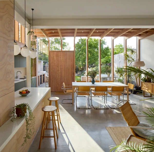 Contemporary 1930s house extension in Walthamstow, E17 featuring exposed timber posts, polished concrete floor, and glass patio doors via Love Locations.