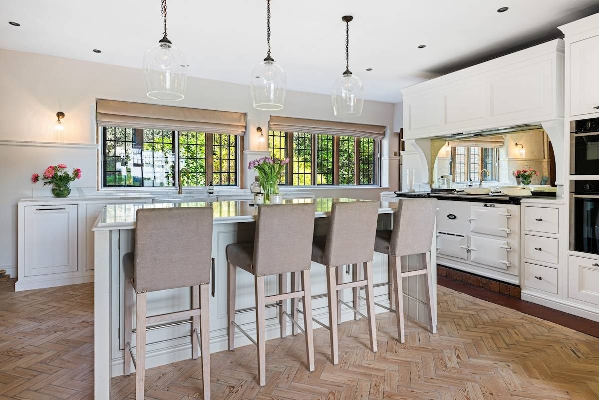 Breakfast bar island featuring high leather bar stools and marble worktops in a modernised country kitchen, Love Locations RH13.