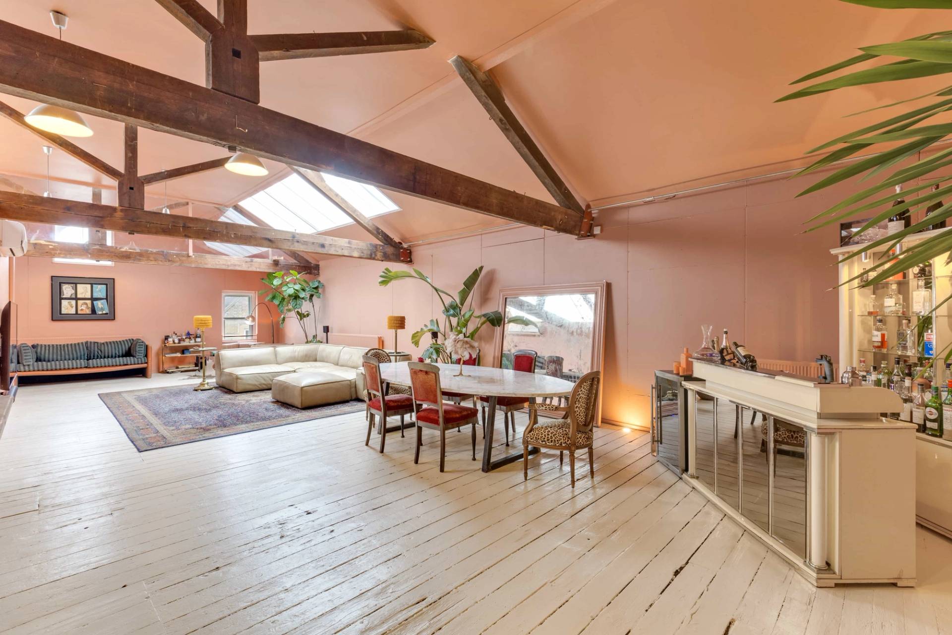 Immensely spacious warehouse apartment studio with timber rafters and distinctive pink backdrop, via Love Locations TW10.