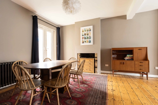 Love Locations traditional dining room London E7: Spacious dining area styled with a dark wood table, vintage patterned rug, mid-century sideboard, and double patio doors, perfect for film productions.