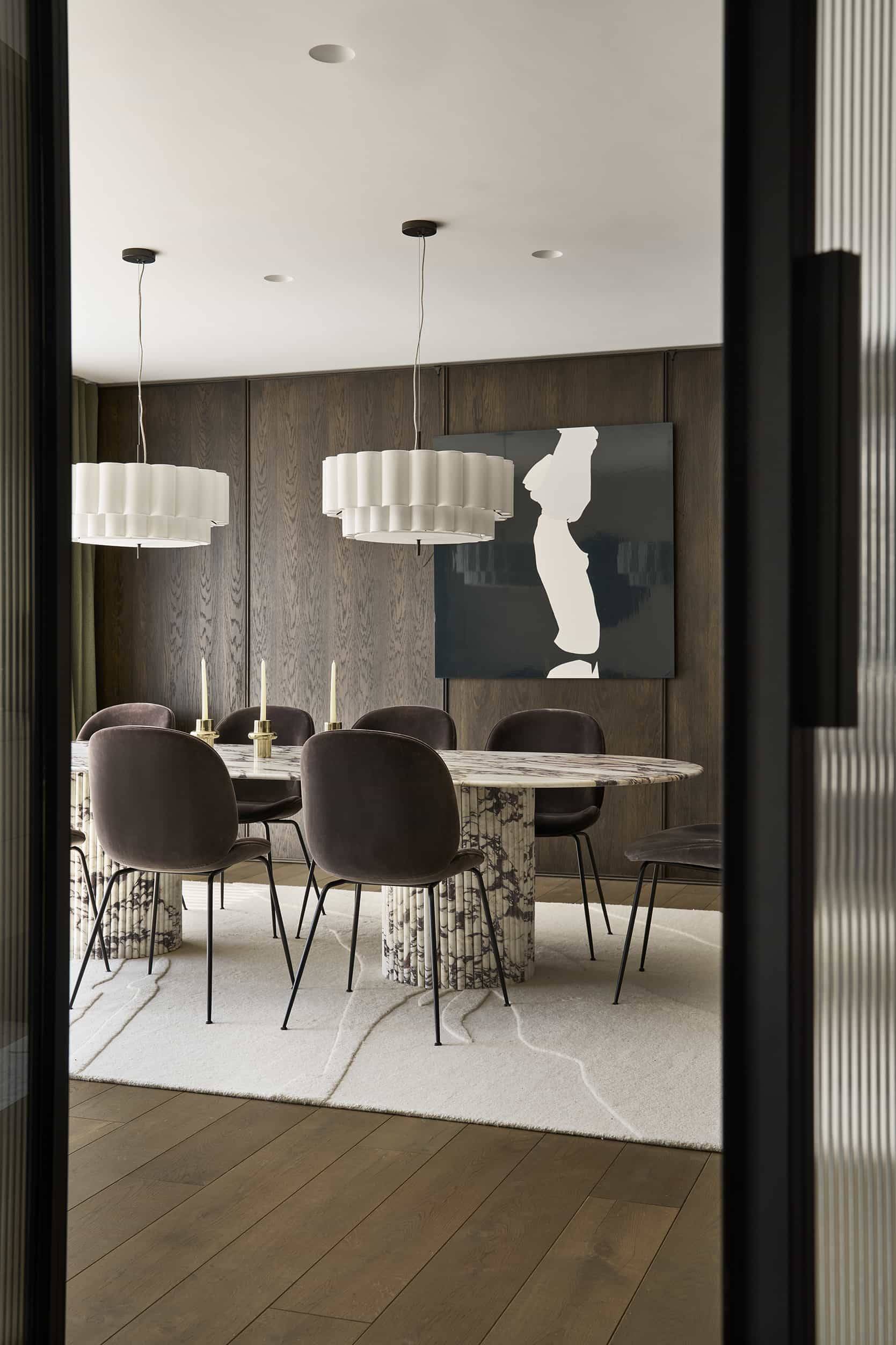 Sophisticated formal dining room location with dark timber panelling and a sculptural marble table, Love Locations.