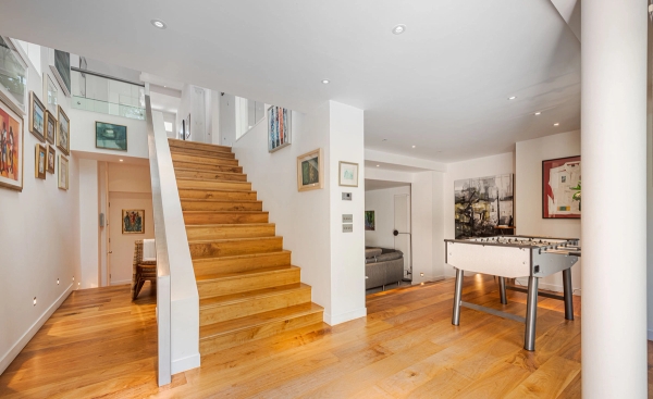 Modern wooden open-tread staircase viewed from the ground level in a Chiswick home, suitable for design and architectural publications, Love Locations W4.
