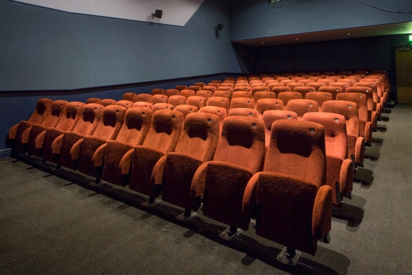 Broad side view across rows of red velvet cinema seating inside The Ritzy Screen 4 production space, curated by Love Locations.