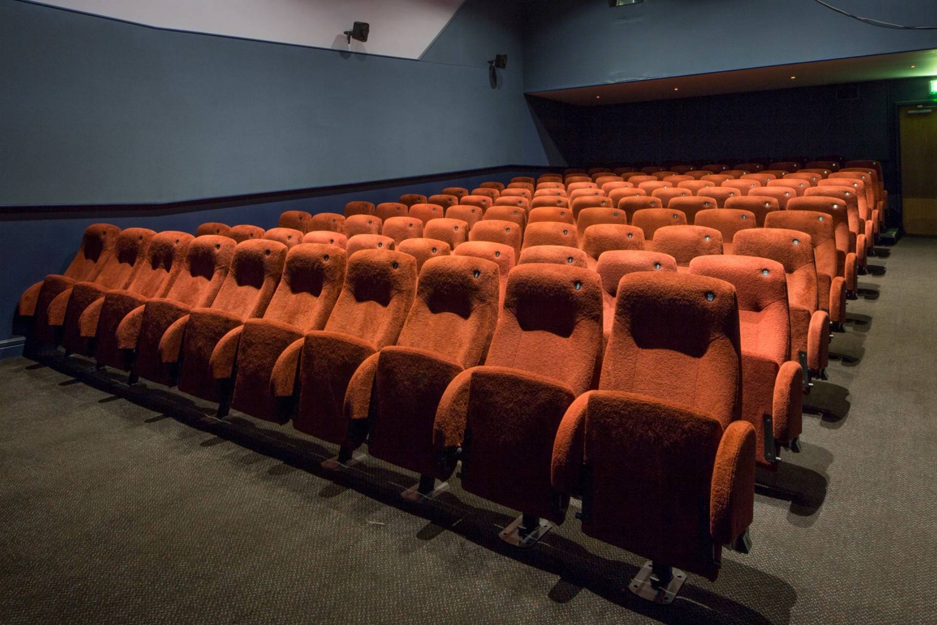Broad side view across rows of red velvet cinema seating inside The Ritzy Screen 4 production space, curated by Love Locations.