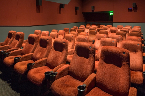 Angled shot across tiered red velvet cinema seating towards the back corner of the auditorium in The Ritzy Screen 4 production venue hire by Love Locations.