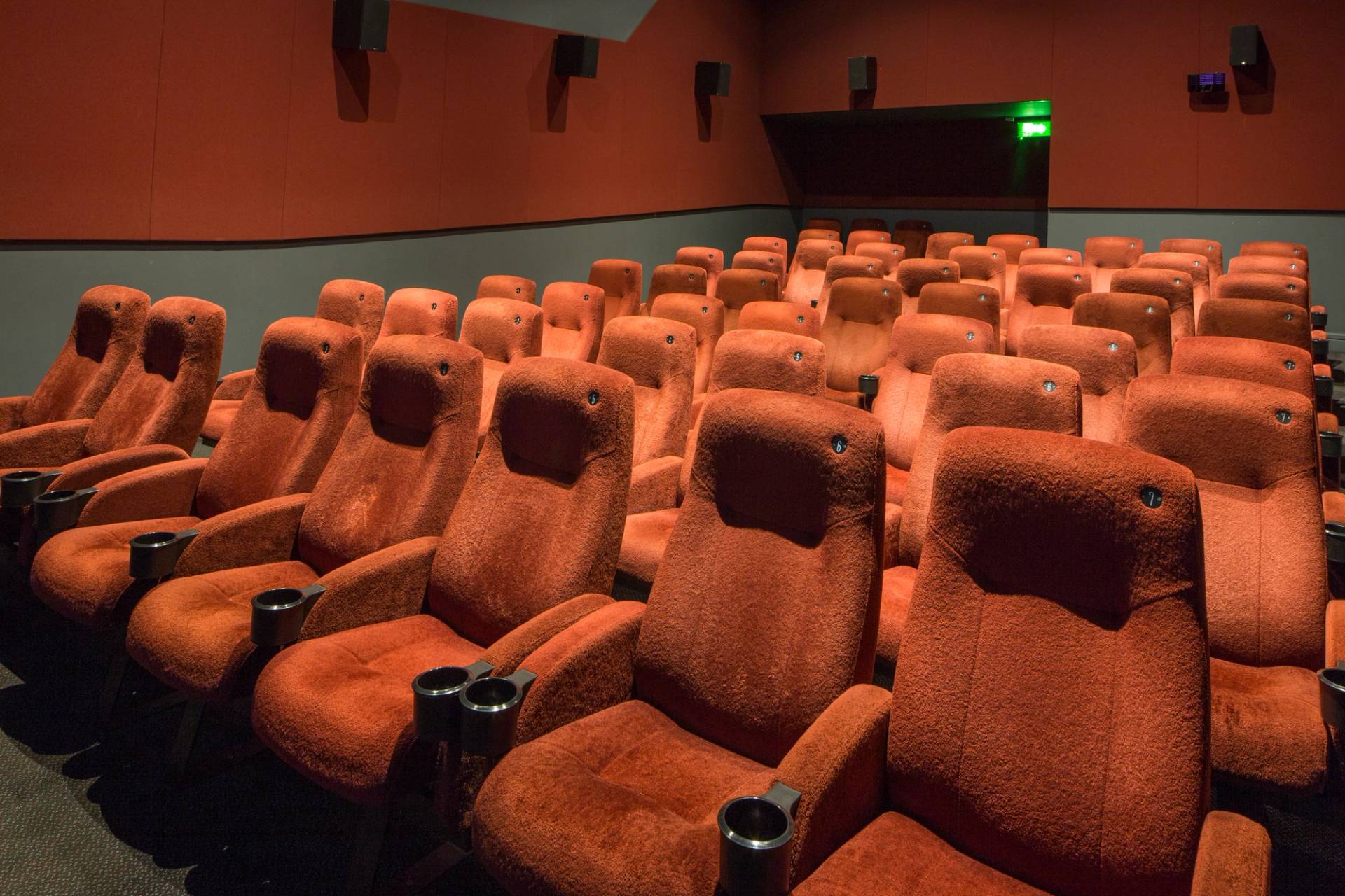 Angled shot across tiered red velvet cinema seating towards the back corner of the auditorium in The Ritzy Screen 4 production venue hire by Love Locations.