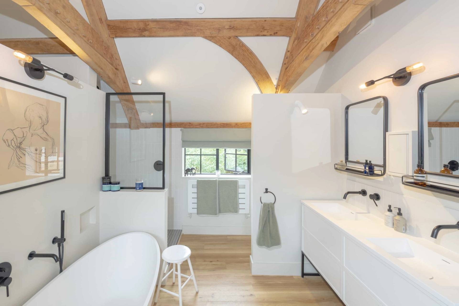 Vaulted bathroom with exposed oak trusses, white soaking tub, and walk-in shower room, Love Locations GU28.