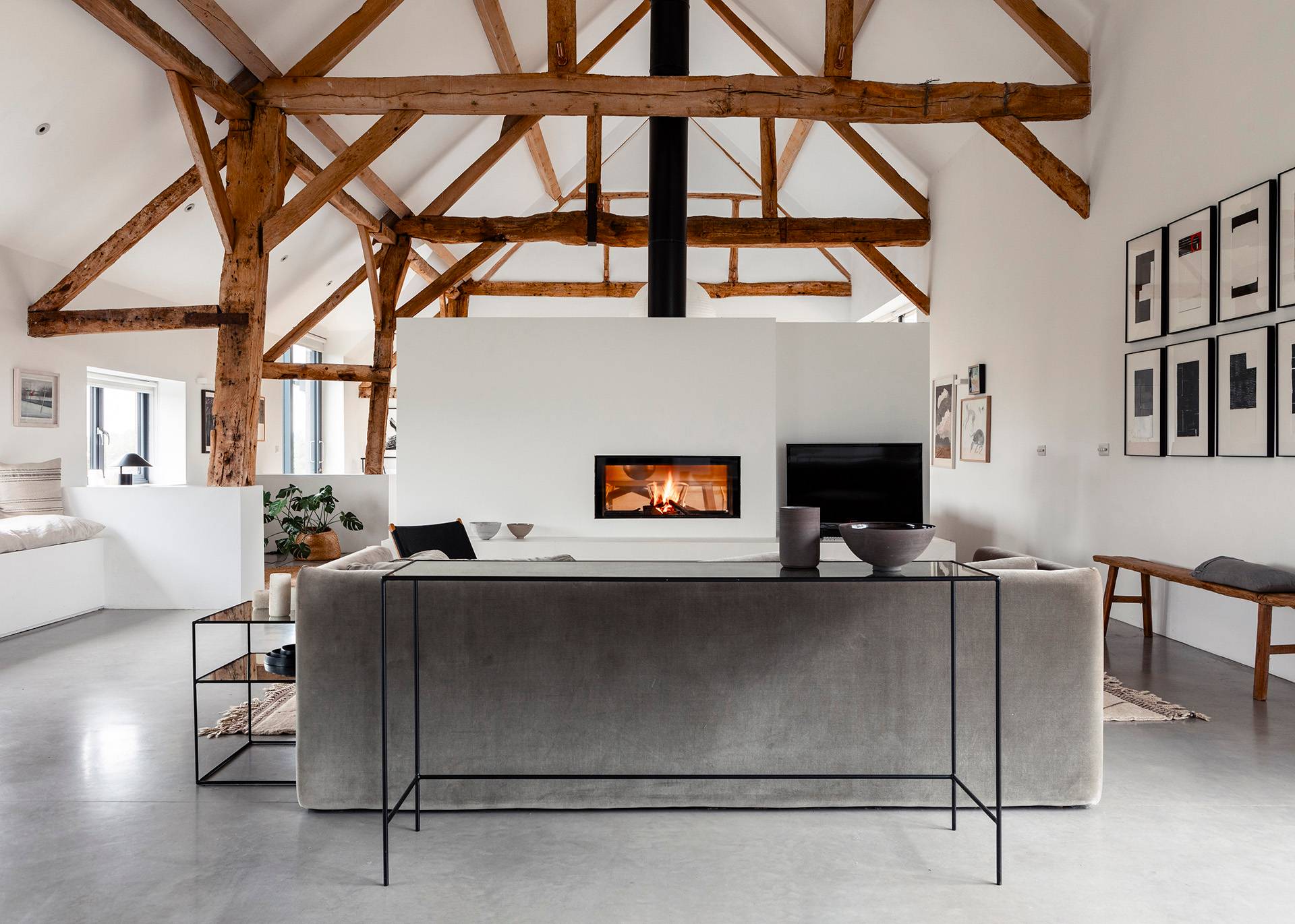 Low-profile console unit set in an open-plan barn conversion under exposed timber roof framing, Love Locations SN8.