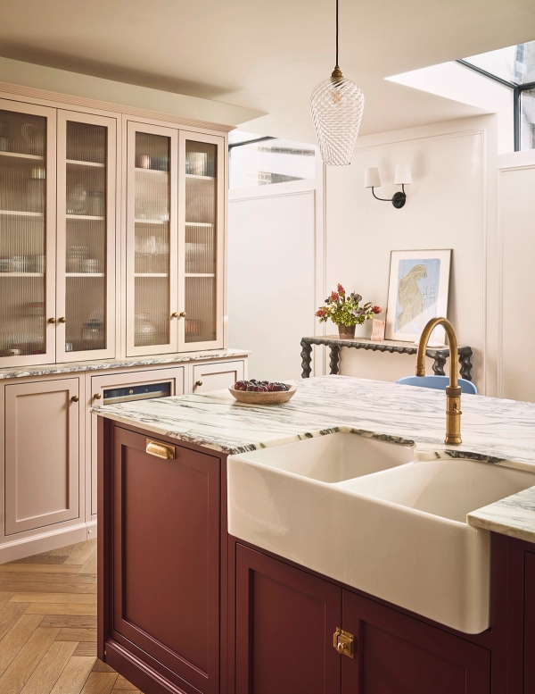 Deep red kitchen island featuring a double ceramic butler sink, brass mixer tap, and marble worktops, Love Locations SE21.