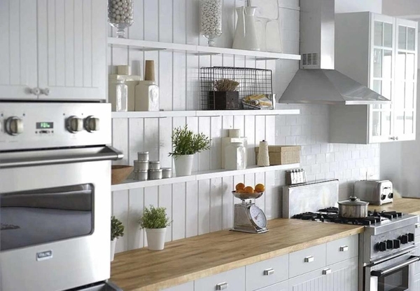 Minimalist kitchen counter workspace featuring wooden countertops, open shelving, and fresh green herbs, perfect for food styling and media shoots, Love Locations.