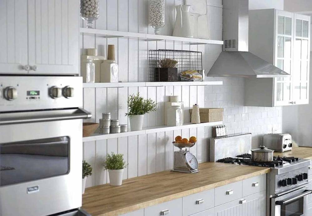 Minimalist kitchen counter workspace featuring wooden countertops, open shelving, and fresh green herbs, perfect for food styling and media shoots, Love Locations.