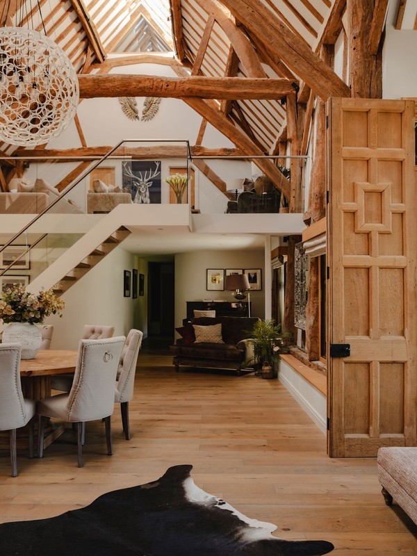 Double-height barn reception hall showing open timber stairs, piano nook, and mezzanine balcony, perfect for music video filming, Love Locations RG9.