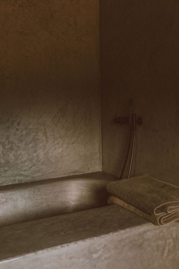 Luxury wet room shower with microcement plaster walls and built-in stone bench, Love Locations 07630.