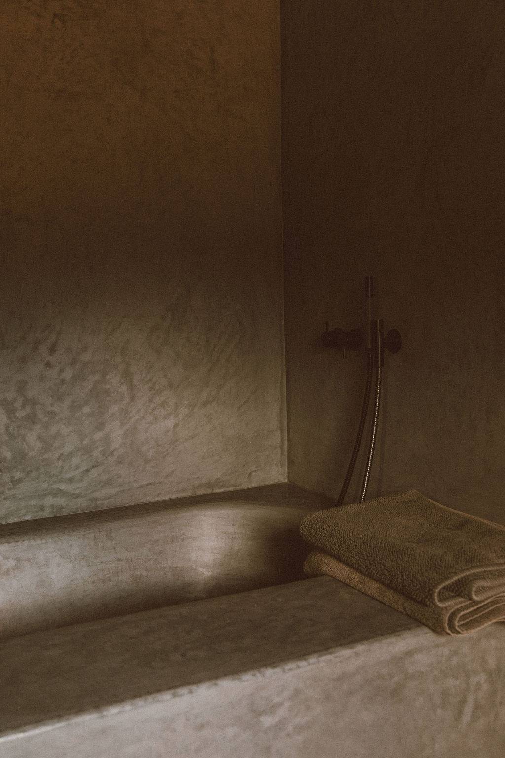 Luxury wet room shower with microcement plaster walls and built-in stone bench, Love Locations 07630.